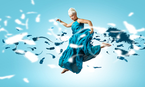 Young attractive woman in blue dress jumping high