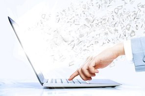 Close up image of laptop and human hands typing on keyboard