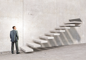 Businessman with suitcase stepping up stone staircase