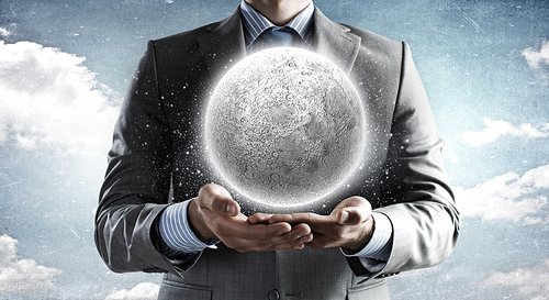 Close of businessman hands holding moon planet