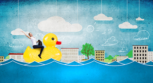 Young happy businesswoman riding yellow rubber duck