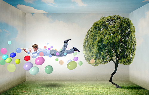 Businessman flying in sky among balloons and looking in spyglass