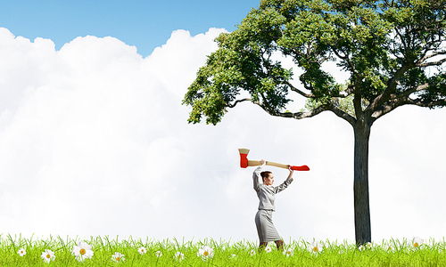 Businesswoman with axe representing problem of deforestation