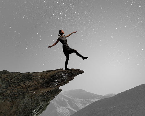 Young woman walking at mountain edge at night