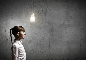 Cute girl of school age and electrical bulb above head
