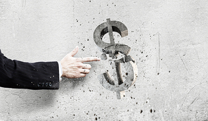 Businessman breaking dollar stone symbol with finger touch