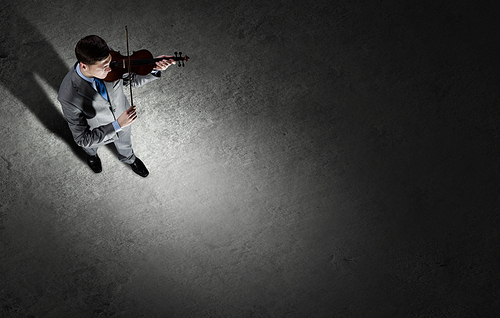 Top view of young businessman playing violin