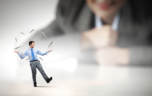 Businesswoman looking at miniature of man juggling with items