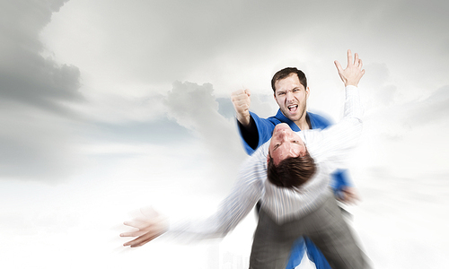 Young determined karate man fighting with businessman in suit