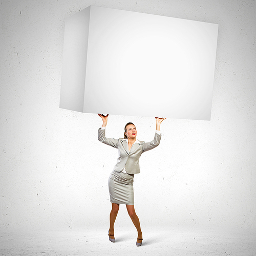 Image of business woman holding heavy white cube above head