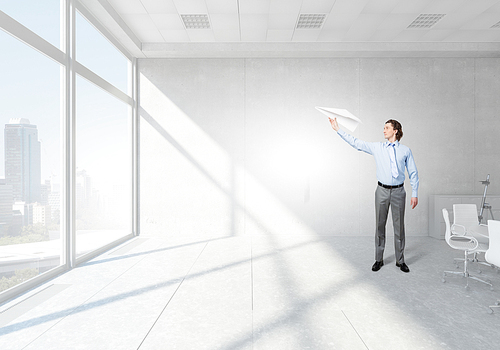 Careless businessman with paper plane in office interior