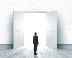 Image of businessman standing in front of opened door