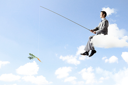 Businessman sitting on cloud and fishing with rod