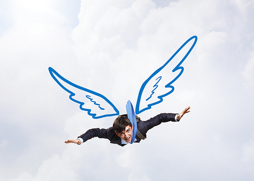 Young businessman with drawn wings flying in sky