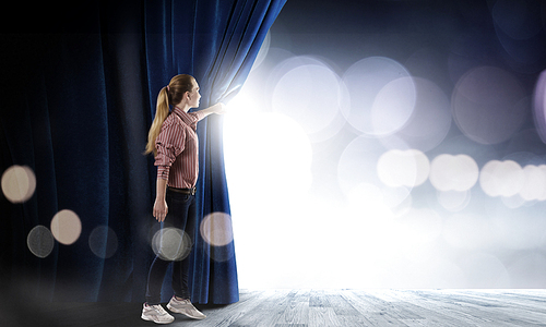 Young woman in casual opening blue curtain