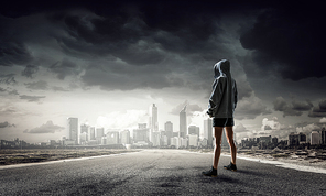 Young boxer woman standing outdoors against city landscape