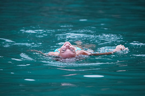 Young woman lying on her back floating in tropical sea water