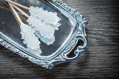 White sugar sticks tray on wooden board.