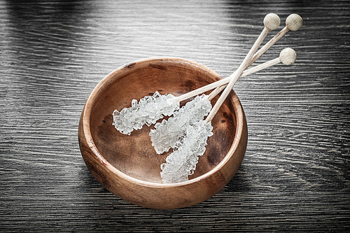 Sugar sticks in wooden bowl.