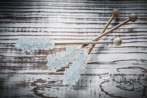 Sweet sugar sticks on vintage wooden board.