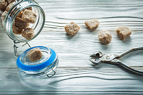 Brown sugar pliers jar on wooden board.