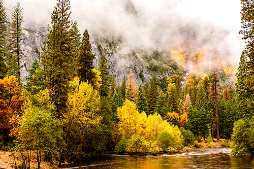 Yosemite National Park Valley and Merced River at autumn. Low clouds lay in the valley. California, USA.