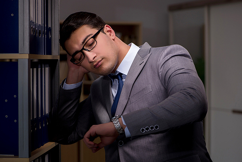 Businessman almost falling asleep working late hours in the office