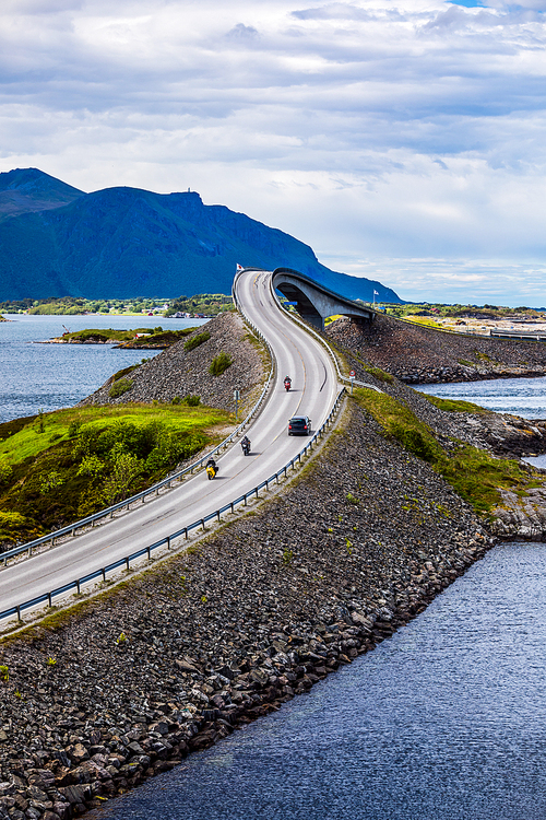 Three bikers on motorcycles. Atlantic Ocean Road or the Atlantic Road (Atlanterhavsveien) been awarded the title as Norwegian Construction of the Century.