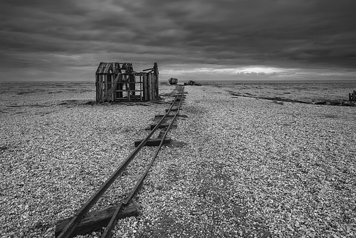 Derelict fishing hut on shingle beach during stormy Winter landscape