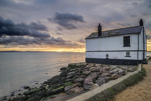 71020544 - landscape image of old abandoned fishing house on england solent coast during moody sunset