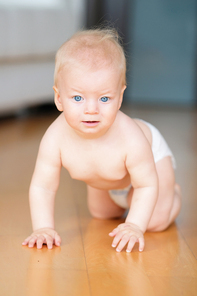 Baby boy crawling on floor