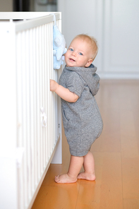 Baby boy with blue eyes learning to walk