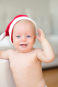 Baby boy with blue eyes christmas portrait in Santa Claus hat