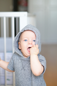 Baby boy with blue eyes learning to walk