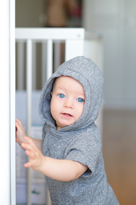 Baby boy with blue eyes learning to walk