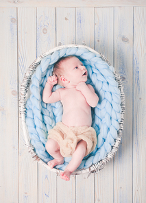 Newborn baby on blue giant crochet blanket look up