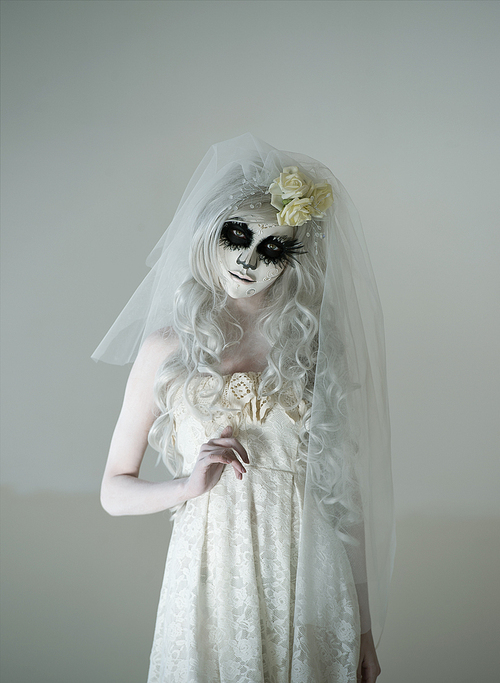 halloween witch. beautiful woman wearing 산타무에르테 mask and wedding dress. dead widow in grief