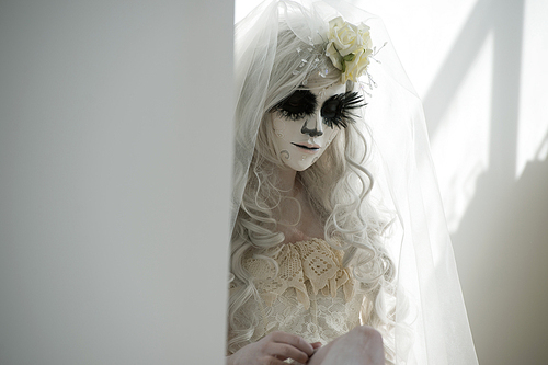 halloween witch. beautiful woman wearing 산타무에르테 mask and wedding dress