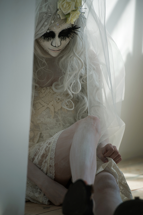 halloween witch. beautiful woman wearing 산타무에르테 mask and wedding dress. dead widow in grief
