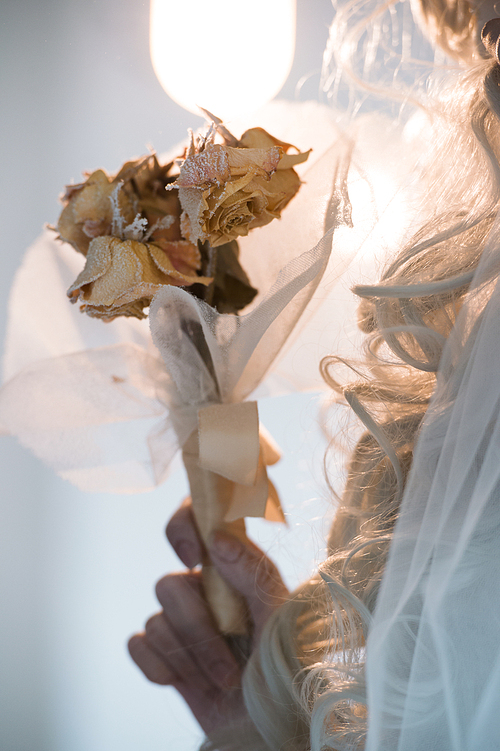 halloween witch. beautiful bride woman wearing 산타무에르테 mask and wedding dress holding dead bouquet of roses