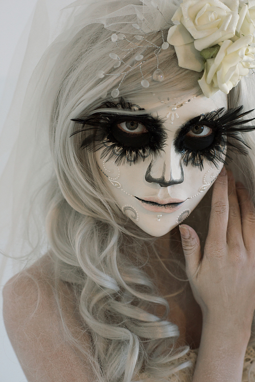 halloween witch. beautiful woman wearing 산타무에르테 mask and wedding dress