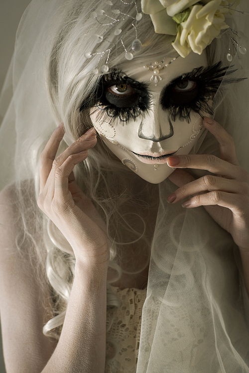halloween witch. beautiful woman wearing s산타무에르테무에르테 mask and wedding dress. dead widow in grief