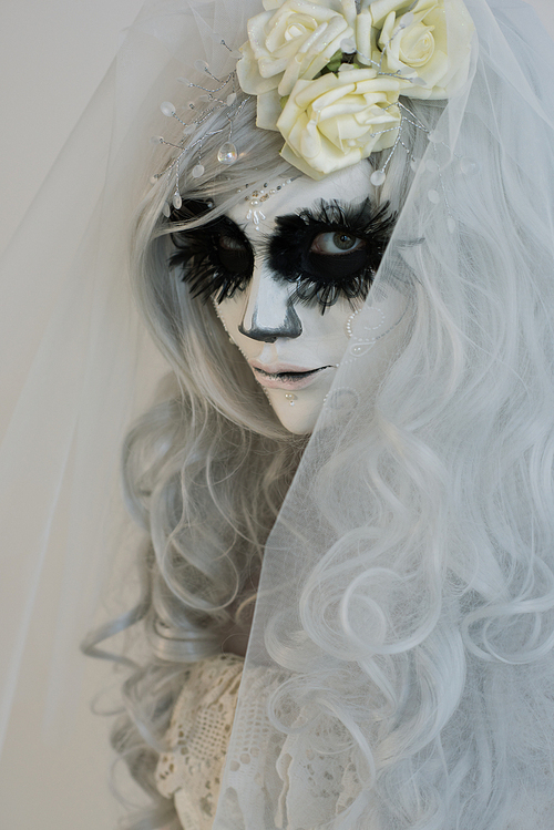 halloween witch. beautiful woman wearing s산타무에르테무에르테 mask and wedding dress
