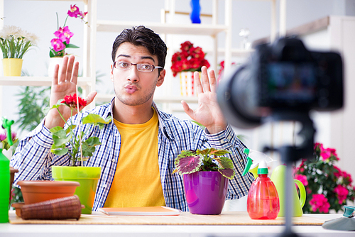 man florist gardener vlogger . shooting video on camera