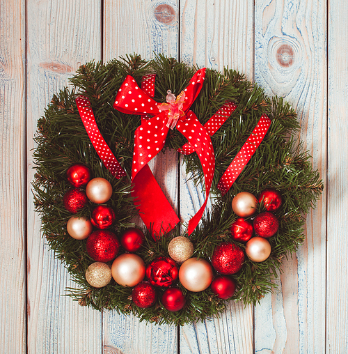 Christmas wreath hanging on blue wooden wall