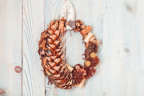 Natural eco Christmas wreath hanging on vintage blue wall