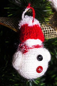 Knitted toy on Christmas tree, close up