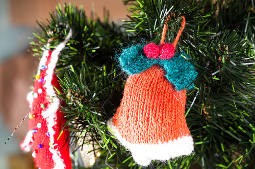 Knitted toy on Christmas tree, close up