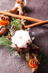 Christmas aromatic decor, cinnamon sticks tied as five-pointed star with rope, acorns and cotton flower