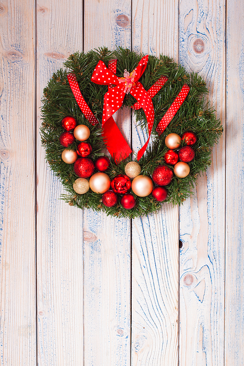 Christmas wreath hanging on blue wooden wall